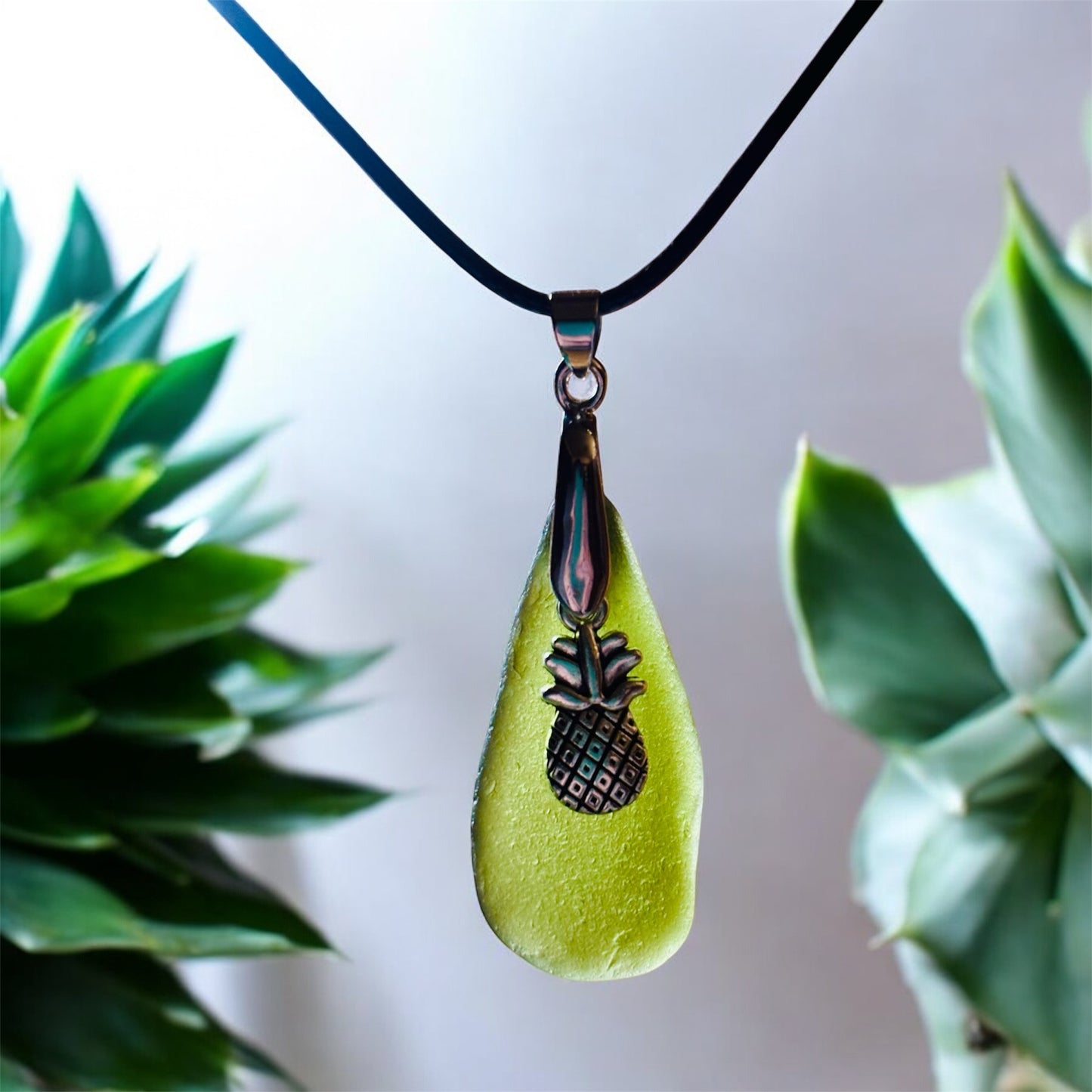 Beautiful Green Seaham sea glass pendant necklace with pineapple charm presented on an 18 inch black nylon chain with a silver lobster clasp
