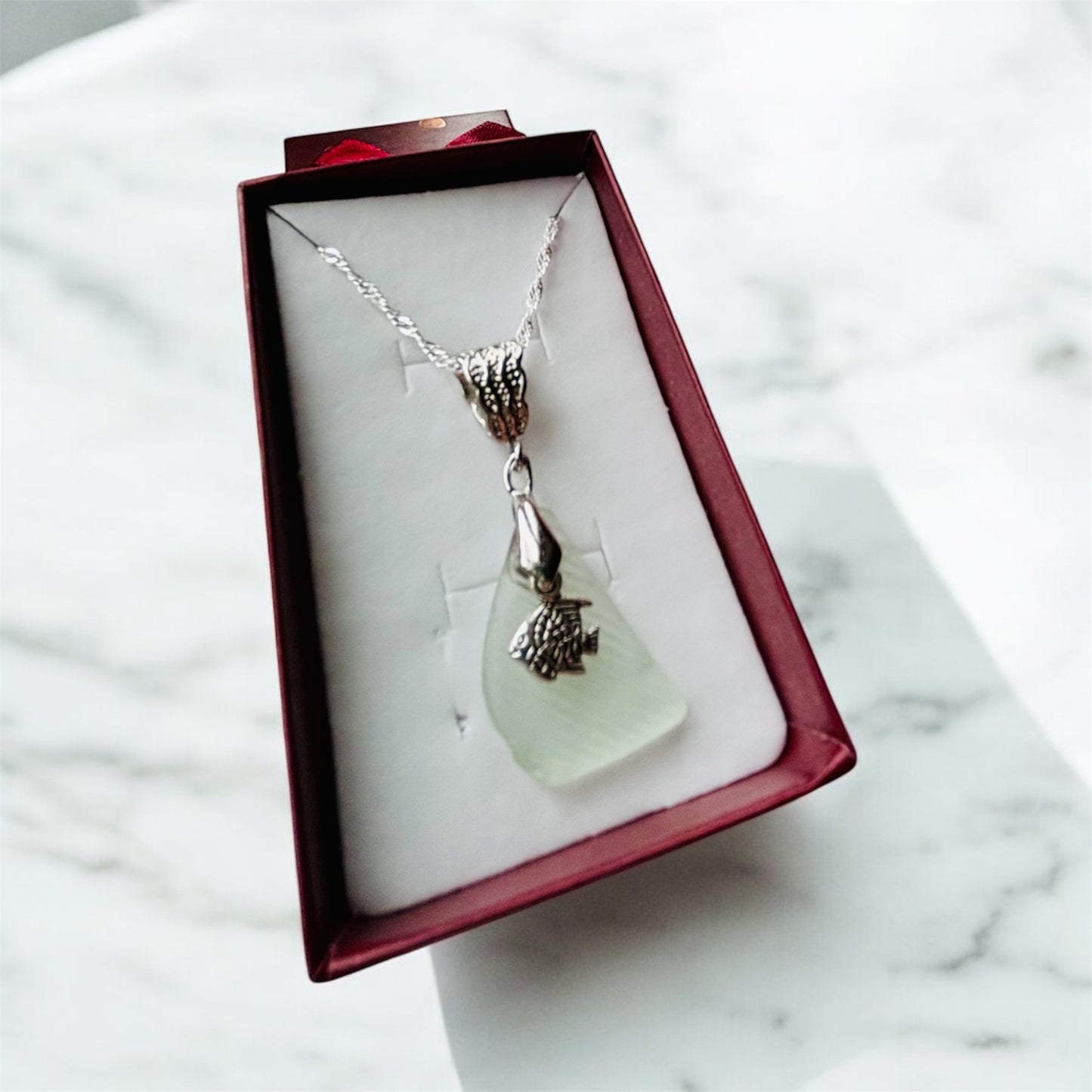 Beautiful handmade White sea glass pendant necklace with fish charm, presented on a 20 inch 925 sterling silver chain
