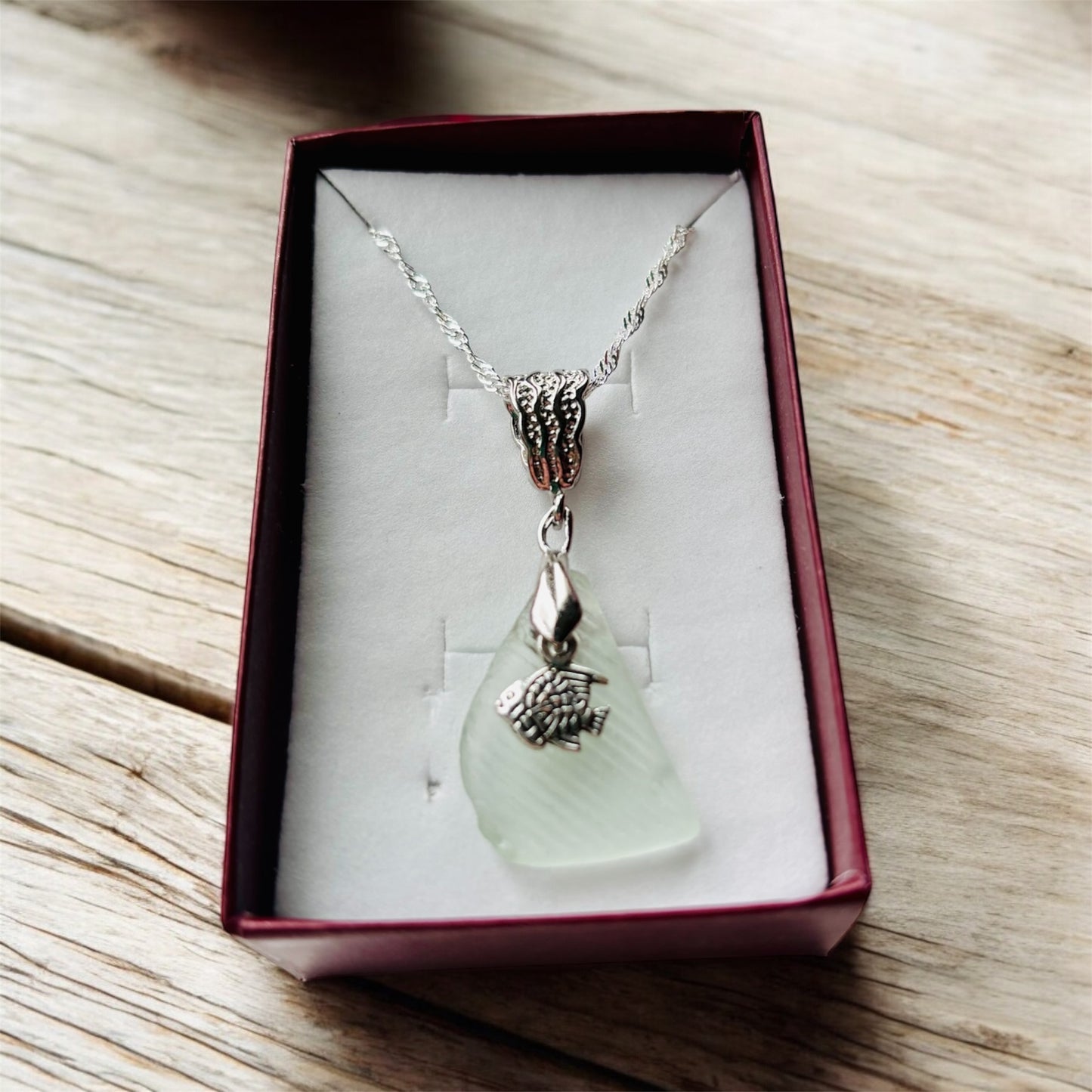 Beautiful handmade White sea glass pendant necklace with fish charm, presented on a 20 inch 925 sterling silver chain